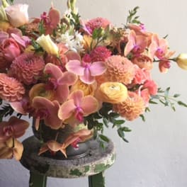 Bouquet of pink and peach flowers in a dark vase