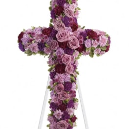 Purple and pink floral cross on a white easel