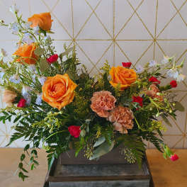 Orange roses and peach carnations in a rectangular wooden container