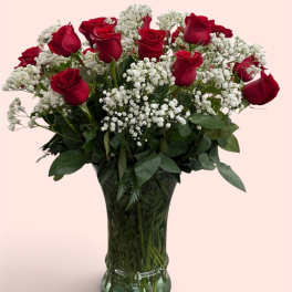 Red roses and white baby's breath in a clear glass vase