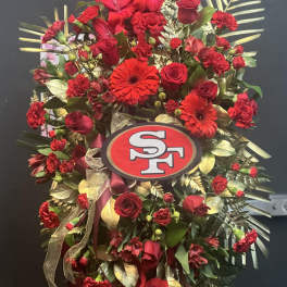 Red floral standing spray with roses and gerbera daisies on an easel