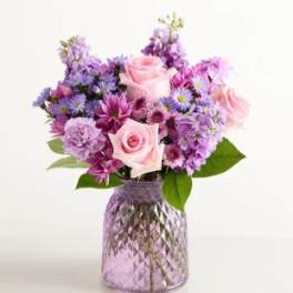Pink and purple mixed bouquet in a textured glass vase