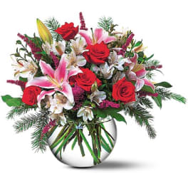 Bouquet of red roses and pink lilies in a round glass vase