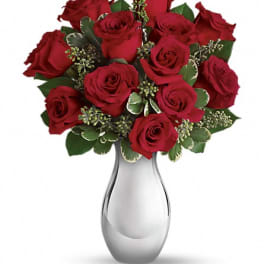 Red roses arranged in a clear glass vase