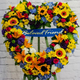Heart-shaped floral wreath with a "Beloved Friend" ribbon