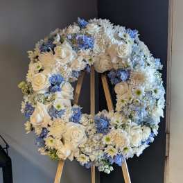 White and blue floral wreath on a wooden easel
