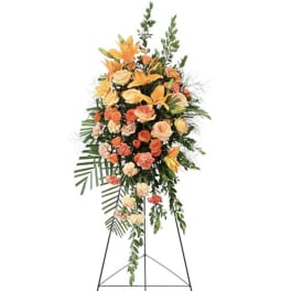 Tall orange and peach floral standing spray on an easel