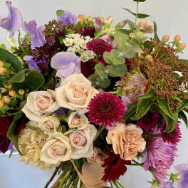 Mixed bouquet with pale roses, purple sweet peas, and magenta blooms