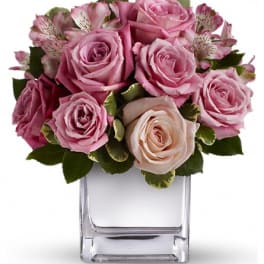 Pink roses and alstroemeria in a clear square vase
