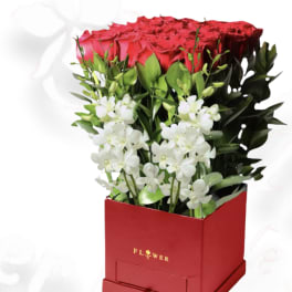Red roses and white orchids in a red box