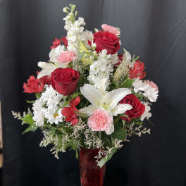 Red roses and white lilies in a red vase