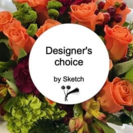 Orange roses with green and burgundy flowers around a designer's choice label