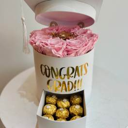 Pink roses in a white graduation gift box with chocolates