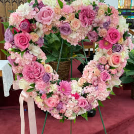 Heart-shaped floral wreath of pink and white roses on an easel