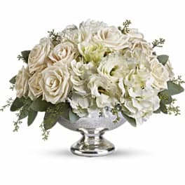 White roses and hydrangeas in a silver pedestal vase