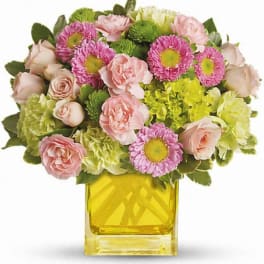Pink and green mixed bouquet in a yellow glass vase