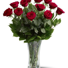 Tall arrangement of red roses in a clear glass vase