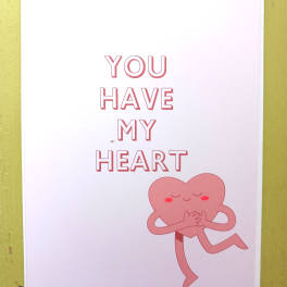 White greeting card with pink text 'You Have My Heart' and a smiling pink heart character hugging itself.
