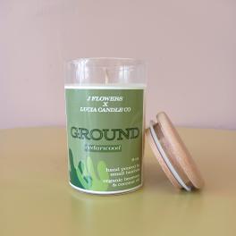 Green cedarwood candle in a glass jar with a wooden lid