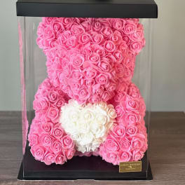 Pink and white rose teddy bear in a clear gift box with a black lid