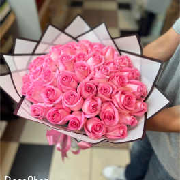 Bouquet of pink roses wrapped in white and dark-edged paper