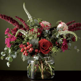 Red and pink floral arrangement in a clear glass vase