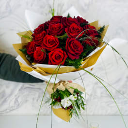 Bouquet of red roses wrapped in white and gold paper
