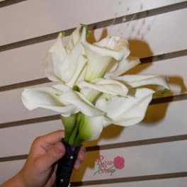 Handheld bouquet of white calla lilies with a dark wrapped stem
