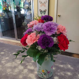 Colorful carnation arrangement in a floral tin vase