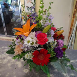 Colorful mixed bouquet with roses, lilies, daisies, and purple blooms