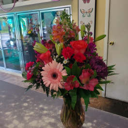 Mixed pink and red flowers in a glass vase