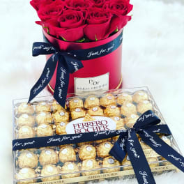 Red roses in a round box with a box of Ferrero Rocher chocolates