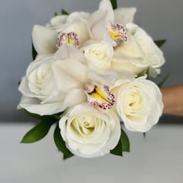 White rose and orchid bouquet with green leaves