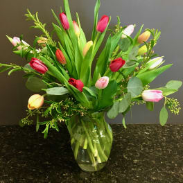 Bouquet of multicolored tulips in a clear glass vase