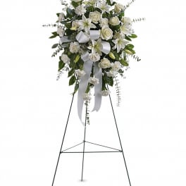 White floral standing spray on a metal easel with ribbon