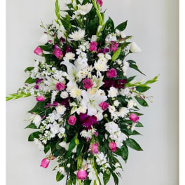 Tall standing floral spray with white lilies, pink roses, and white daisies