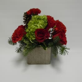 Red roses and carnations in a square vase with green hydrangea