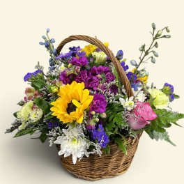 Mixed flower basket with a sunflower, roses, and daisies
