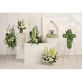 White and green funeral floral arrangements displayed on pedestals and stands