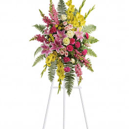 Tall standing floral spray with pink, yellow, and white flowers on an easel