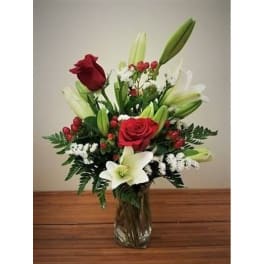 Red roses and white lilies arranged in a clear glass vase