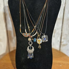Layered pendant necklaces on a black display bust
