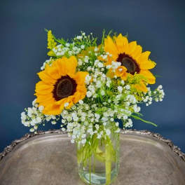 Sunflowers and white baby's breath in a clear glass vase