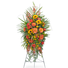 Tall standing floral spray with orange roses and yellow sunflowers on an easel