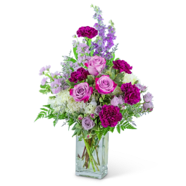 Pink and purple flower arrangement in a clear glass vase