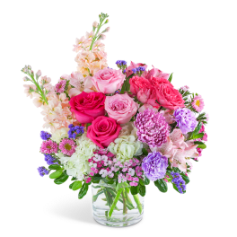 Pink and purple mixed flower bouquet in a clear glass vase