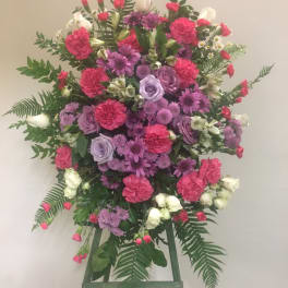 Large standing floral spray with pink, purple, and white blooms