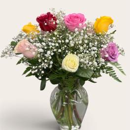 Mixed roses in a clear glass vase with baby's breath