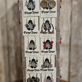 Display rack of assorted dangling earrings on PearTree Jewelry cards