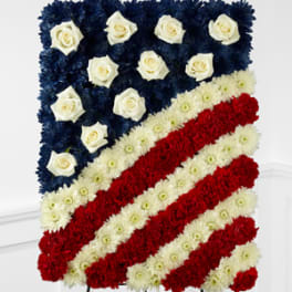 Floral arrangement shaped like the American flag with red, white, and blue flowers